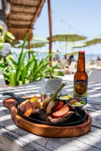 普拉亚卡门考利布里海滩酒店的桌上的一盘食物和一瓶啤酒