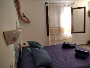 奥罗塞伊Cuccuru Relax - A IUN Q9882的一间卧室配有一张带枕头的紫色床和窗户。