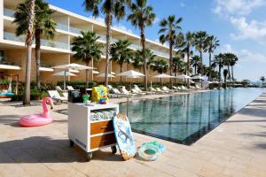坎昆Family Selection at Grand Palladium Costa Mujeres Resort & Spa - All Inclusive的度假村旁的带游泳池和冲浪板的度假村