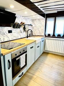 Soto en CamerosLa casita del rio的厨房配有白色橱柜和炉灶烤箱。