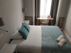 里斯本法克罗斯3号旅馆的一间卧室配有一张大床和毛巾