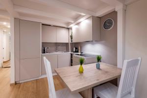 米兰FCM Tourism - Rosales Studio的厨房配有木桌和白色橱柜。