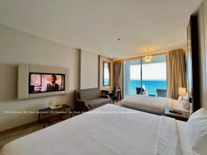 芽庄Panorama Apartment Nha Trang的一间酒店客房,配有一张床和一台电视