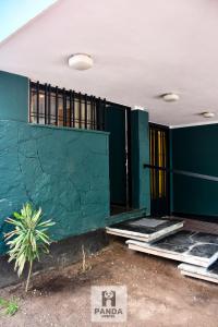 门多萨Panda Hostel Mendoza的一座拥有绿色墙壁和一些窗户的建筑