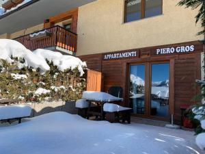 萨奥兹-杜尔克斯Appartamenti & Wellness Piero Gros的一座楼房,在餐厅前有雪盖桌子