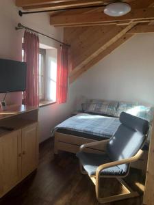 克维尔达Apartmány Verunka的一间卧室配有一张床、一台电视和一把椅子