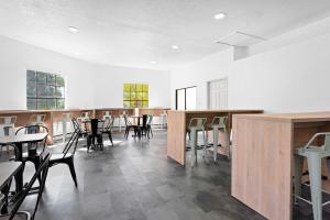 基西米Developer Inn Maingate, a Baymont by Wyndham的大楼内带桌椅的用餐室