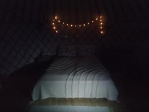 拉茨凯韦Jurtafarm Ráckeve - a nomád luxus的一间卧室配有白色的床和灯。