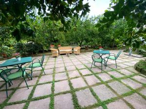 索伦托IL GLICINE的庭院设有2张桌子和椅子,树木繁茂。