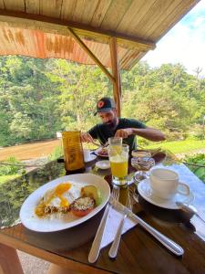 ArchidonaPlaya Selva Lodge的坐在餐桌上吃一盘食物的人