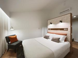 科维良Alto do Ferrum - Boutique Villa的卧室配有一张白色大床和一把椅子