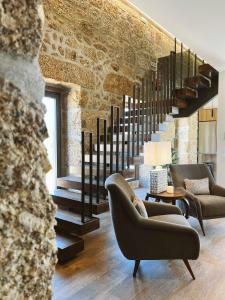 科维良Alto do Ferrum - Boutique Villa的一间带两把椅子和楼梯的客厅