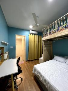 汝来Lapan Ompek Homestay 3 Bedrooms的一间卧室配有一张床、一张桌子和一张双层床。