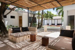 普拉亚卡门Aalada Playa del Carmen的户外庭院配有沙发和桌子。