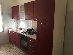 卡坦扎罗Appartamento relax a Catanzaro Lido的厨房配有红色橱柜和炉灶烤箱