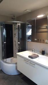 马尔梅迪Terrasses de Malmedy - Duplex 455的带淋浴、两个盥洗盆和浴缸的浴室