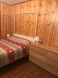 大圣玛丽亚Appartamento Santa Maria Maggiore的一间卧室设有两张床和木墙