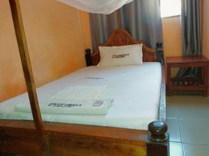 巴加莫约California Lodge的一间卧室配有一张带木制床架的床