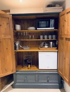 贝德福德2 Beds & living in our idyllic country Cottage的一间带木制橱柜和微波炉的厨房