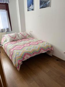圣伊西德罗San Isidro Estación de Esqui的卧室内一张带五颜六色棉被的床
