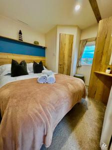 Newquay Bay ResortNewquay Bay Resort - Summer Days 135的一间卧室配有一张大床和两条毛巾