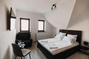 CăpîlniţaBORSIKA PENSIUNE & SPA的一间小卧室,配有一张床和一把椅子