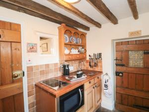 阿克顿特维尔Pike Cottage的厨房配有木制橱柜和炉灶烤箱。
