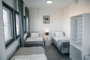 赫尔辛基Inn Tourist Hostel的配有2张床的白色墙壁和窗户客房