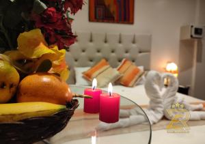 马丘比丘Real Excelencia的一张桌子,上面放着两根蜡烛和一碗水果