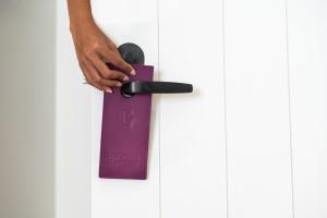 拿骚Goldwynn Resort & Residences的一个人拿着紫色的门把手