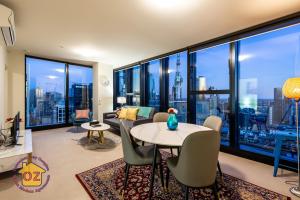 墨尔本Aussie Escape Apartments的客厅配有桌椅和大窗户