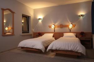 卢森堡塞维伯恩酒店的一间卧室配有两张床、镜子和灯