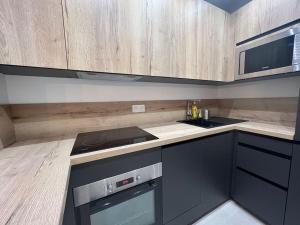 尼斯Place Massena, superbe appartement neuf.的厨房配有木制橱柜和炉灶烤箱。