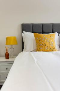 皮特洛赫里Lovely 2 bed house in Pitlochry的卧室配有白色的床和带台灯的床头柜。