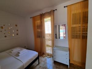 格利法达Corfu Dream Holidays Villas的一间卧室配有一张床、一个梳妆台和一扇窗户。
