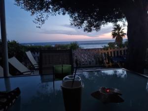 格利法达Corfu Dream Holidays Villas的玻璃桌,一边享用饮品一边欣赏海景