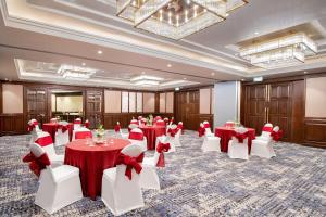 达兰萨拉Radisson Blu Resort Dharamshala的宴会厅配有红色和白色的桌椅