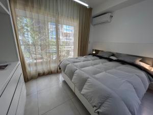布宜诺斯艾利斯Wehome Buenos Aires的一间卧室设有一张大床和一个窗户。