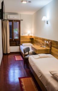 奥韦拉Hotel Cuatro Pinos的客房设有两张床和一张书桌