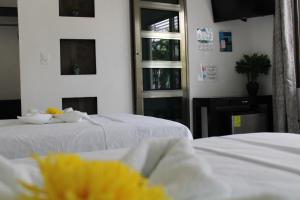 巴卡拉尔Casa Zazil的客房设有2张带白色床单的床和窗户。