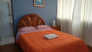 万查科Hospedaje Fremiott的一间卧室配有一张带橙色毯子的床