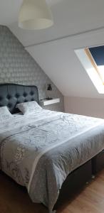 勒特雷波尔Le Paradis des Fleurs的一间卧室配有一张大床和黑色床头板