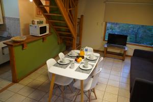 乌斯怀亚La Barranca的一间设有白色桌子和白色椅子的用餐室