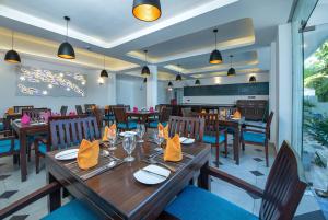 坦加拉Grand Samudra Hotel的餐厅配有木桌和椅子