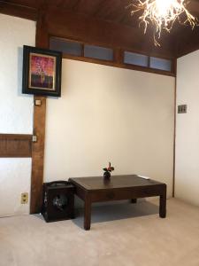 壹岐市島宿糸的一间墙上挂着一张桌子和一张照片的房间