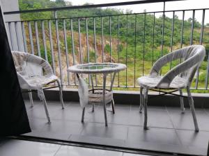 汝来H&H Lovely Homestay in Nilai (Residensi Lili)的美景阳台配有三把椅子和一张桌子