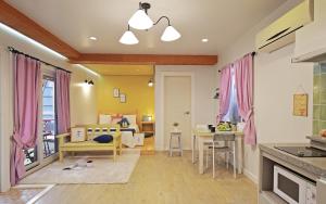 庆州庆州提阿莫度假屋的一间厨房、一间带粉红色窗帘的客厅和一间卧室