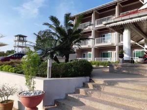 珍南海滩王谷度假酒店的前面有棕榈树的建筑