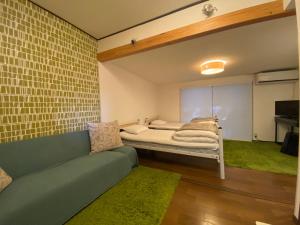 直岛町Bamboo Village Guest House的客厅配有沙发和1张床