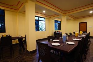 甘托克Hotel White Lotus Gangtok的用餐室设有桌椅和窗户。